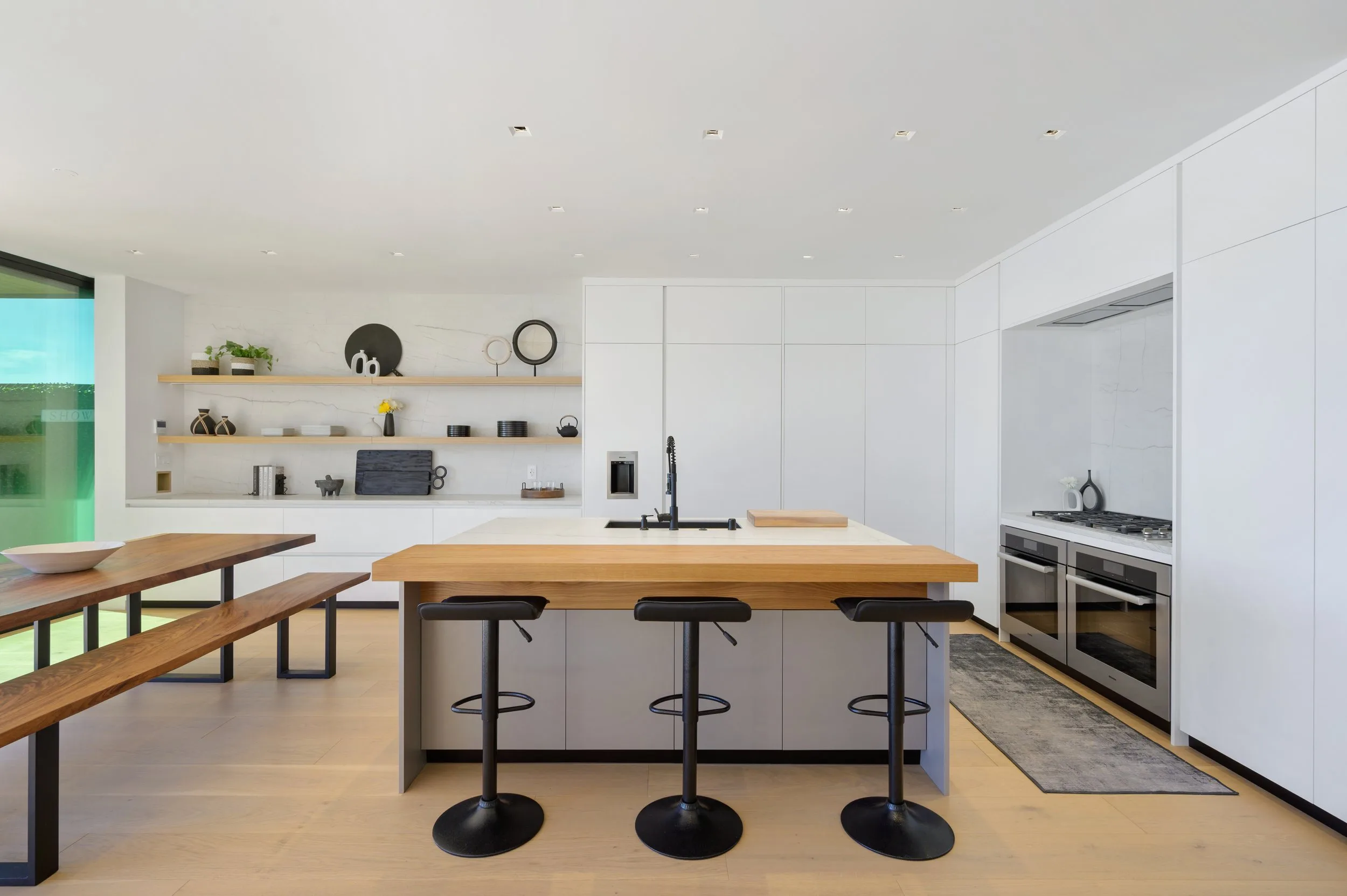 Modern minimalist kitchen remodel by Amerbuild in Los Angeles featuring custom island with wood countertop and open shelving